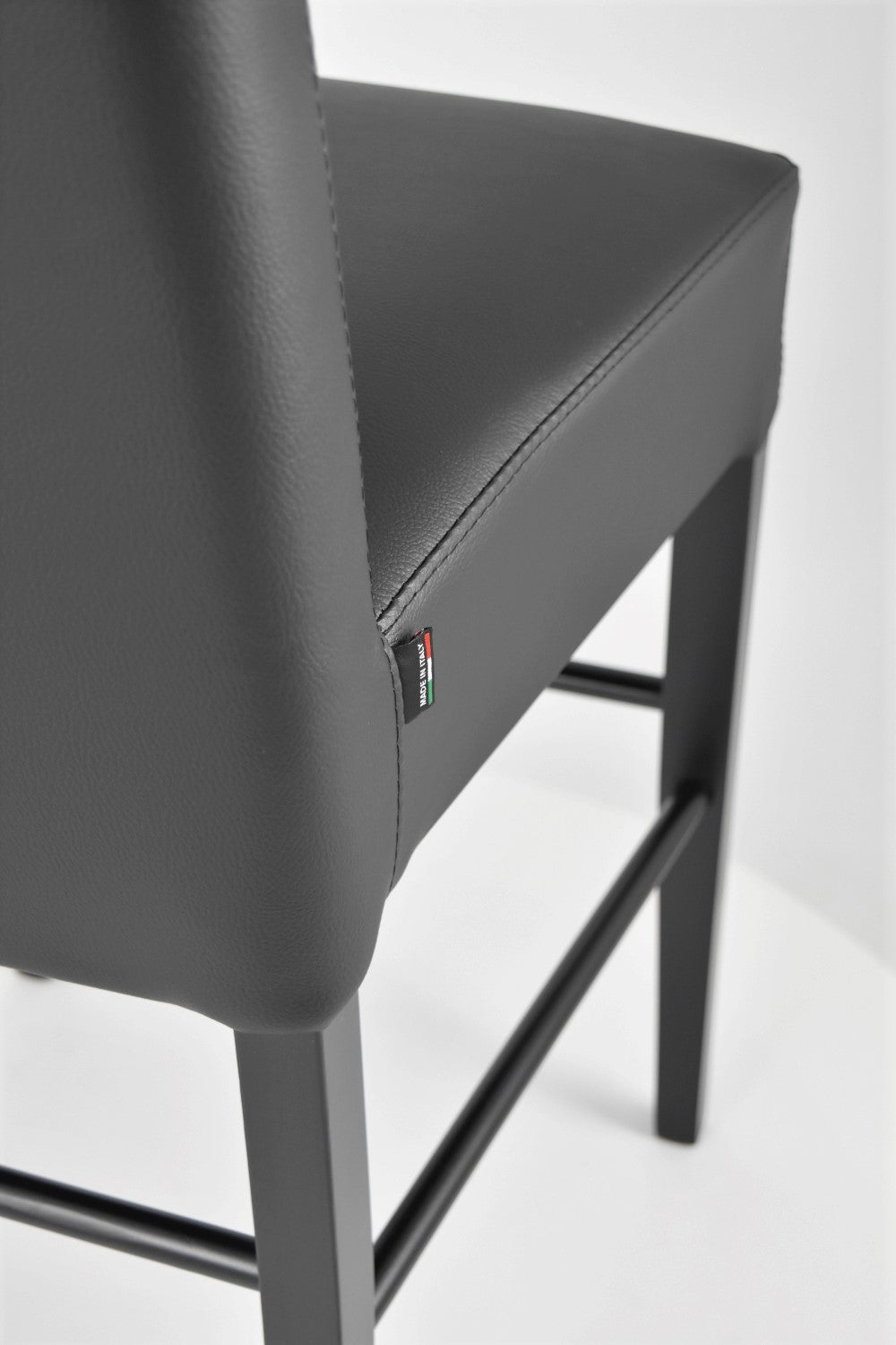 Luisa low stools in beech wood structure, padded seat and backrest covered in artificial leather
